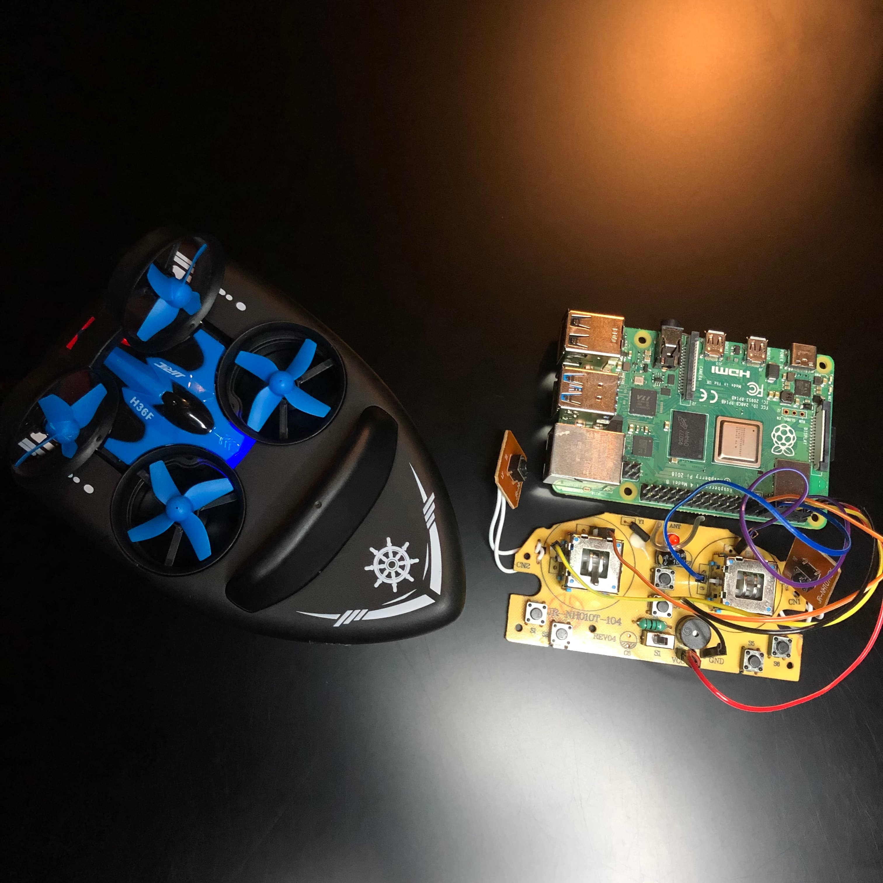 Opened drone controller electronics beside a Raspberry Pi used for the control-interface prototype.